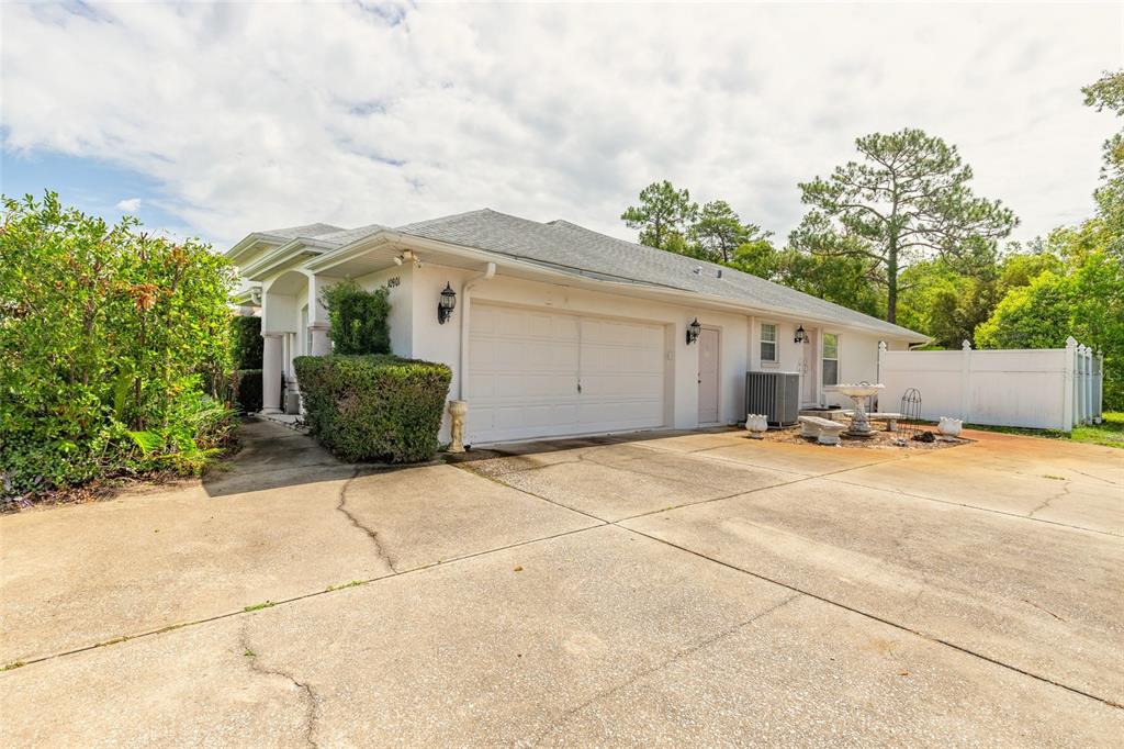 A single-story house with a white exterior, a two-car garage, and a concrete driveway — 10901 SW 55TH AVENUE, OCALA, FL
