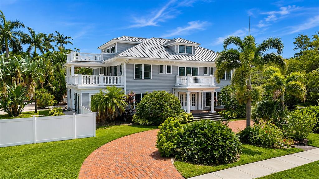 A large, three-story gray house with a metal roof and a brick driveway — 403 MAGNOLIA DRIVE, CLEARWATER, FL