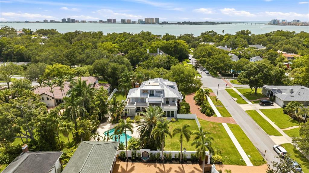 An aerial view shows a multi-story house with a pool, surrounded by trees and streets — 403 MAGNOLIA DRIVE, CLEARWATER, FL