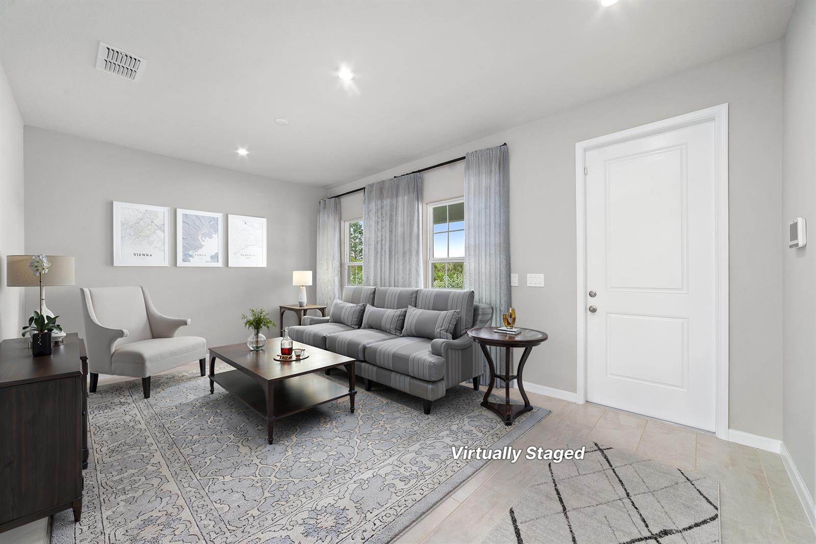 This living room features gray walls, a striped sofa, a coffee table, and a rug — 6555 Pomello Court, Vero Beach FL 32967, VERO BEACH, FL