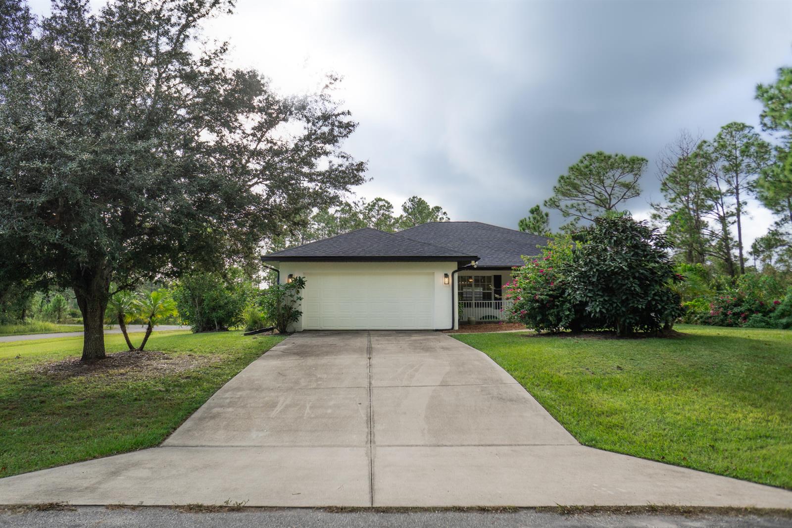 A single-story house with a white garage door, dark roof, and a concrete driveway — 9134 Oviedo Street, Sebring FL 33872, SEBRING, FL