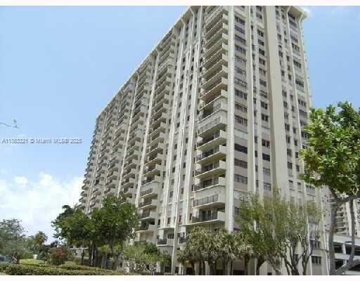 A tall, beige residential high-rise building stands against a clear blue sky — 1201 S Ocean Dr # 2404S, Hollywood FL 33019, HOLLYWOOD, FL