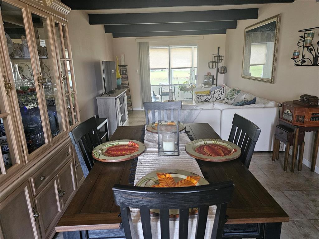 A dining area with a wooden table and hutch opens into a living room space — 915 CLUB CIRCLE, LAKESHORE, FL