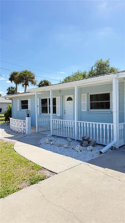 A light blue house features a covered front porch with white railings and a concrete walkway — 491 S VENICE BOULEVARD, VENICE, FL