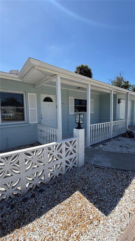 A light blue house features a white front door, a decorative concrete wall, and gravel landscaping — 491 S VENICE BOULEVARD, VENICE, FL