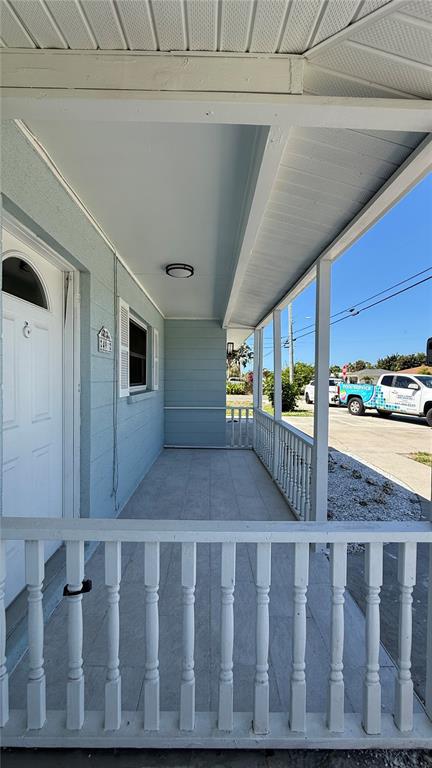 A covered front porch with white railings, a light blue exterior wall, and a white door — 491 S VENICE BOULEVARD, VENICE, FL