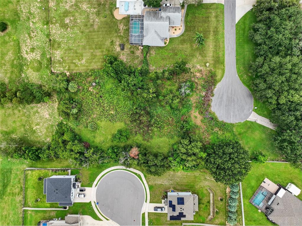 An aerial view shows a vacant, wooded residential lot situated between two cul-de-sacs — TBD KANUBA COURT, CLERMONT, FL