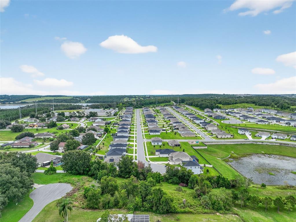 An aerial view shows a suburban neighborhood with rows of houses and a retention pond — TBD KANUBA COURT, CLERMONT, FL