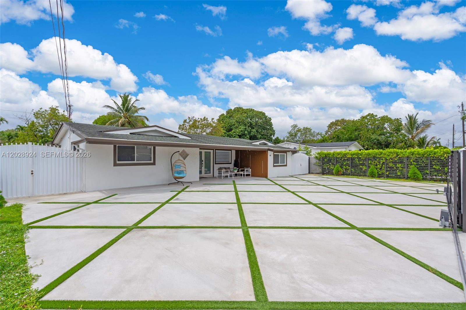A white house features a large concrete driveway with artificial turf grid lines — 46 NE 164th St # 0, Miami FL 33162, MIAMI, FL