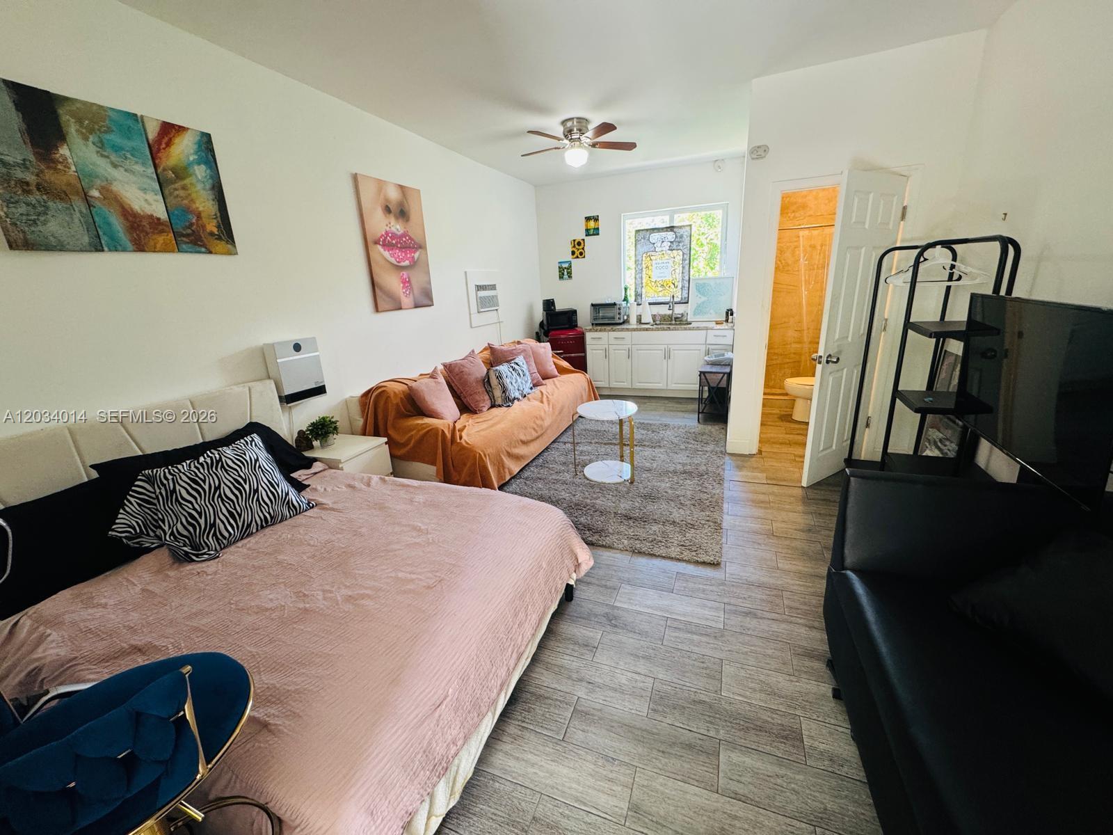 This studio apartment features a bed, a sofa, a kitchenette, and an attached bathroom — 11 NW 47th Ter # 1B, Miami FL 33127, MIAMI, FL