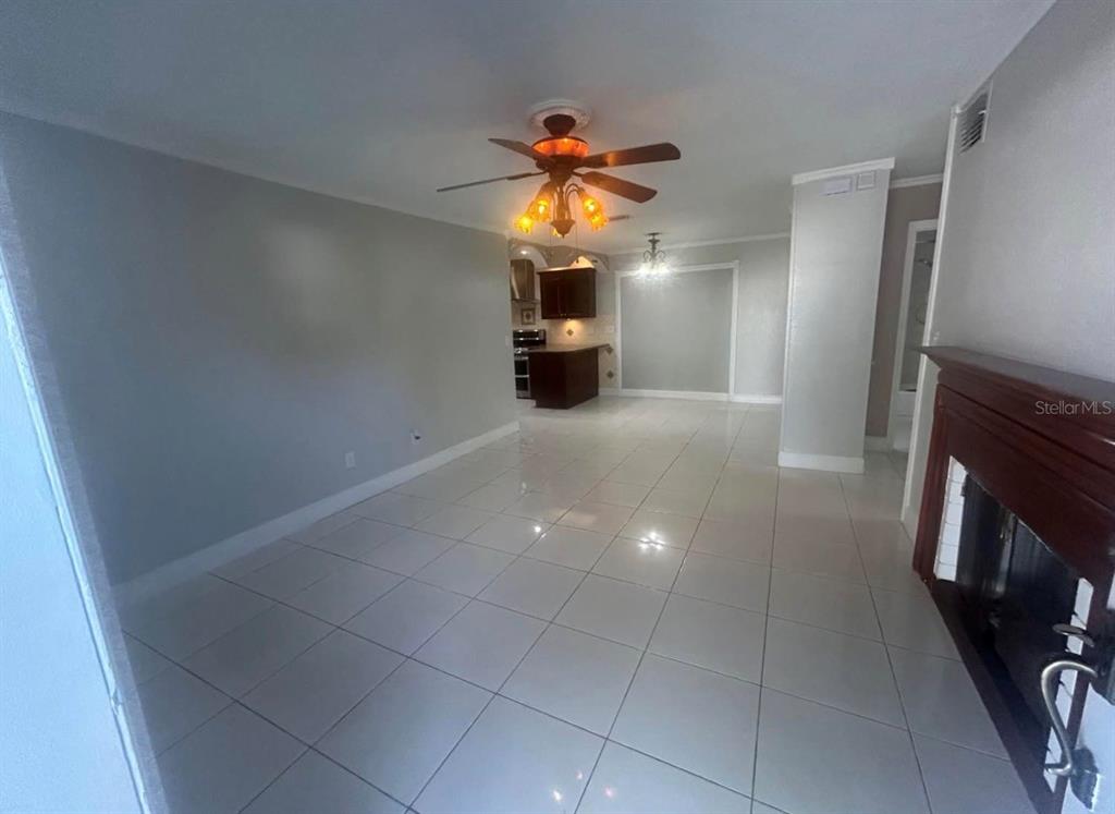 An open-concept living area features light-colored tile flooring, a ceiling fan, and a fireplace — 5112 GATEWAY DRIVE, TAMPA, FL