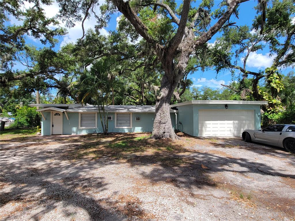 A light blue single-story house with a garage and a large tree in the yard — 1375 MYRTLE STREET, SARASOTA, FL