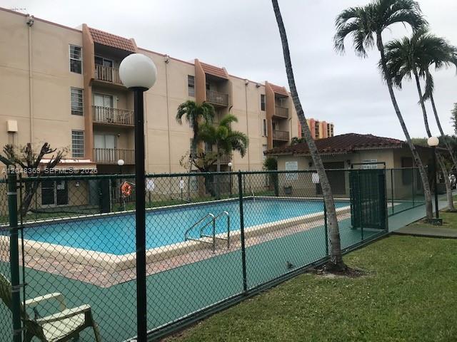 An outdoor swimming pool is enclosed by a chain-link fence next to a multi-story building — 4715 NW 7th St # 2, Miami FL 33126, MIAMI, FL