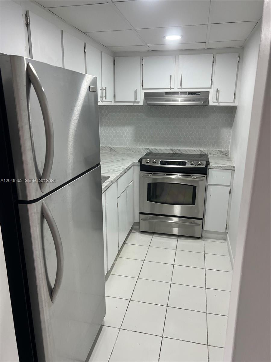 A galley kitchen features white cabinets, stainless steel appliances, and light-colored tile flooring — 4715 NW 7th St # 2, Miami FL 33126, MIAMI, FL