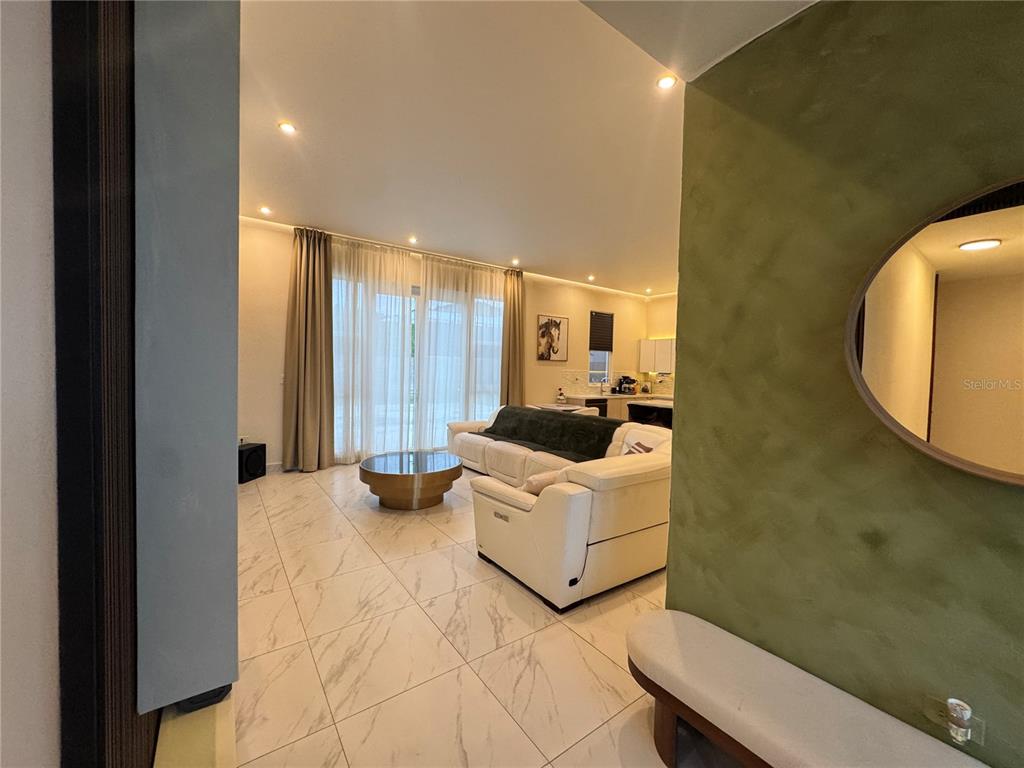 A living room features white tile floors, a white sectional sofa, and floor-to-ceiling curtains — 201 GUADIANA, GURABO, PR