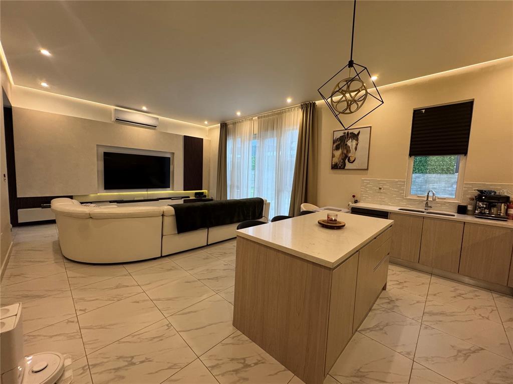 An open-concept living room and kitchen featuring a white sectional sofa and center island — 201 GUADIANA, GURABO, PR