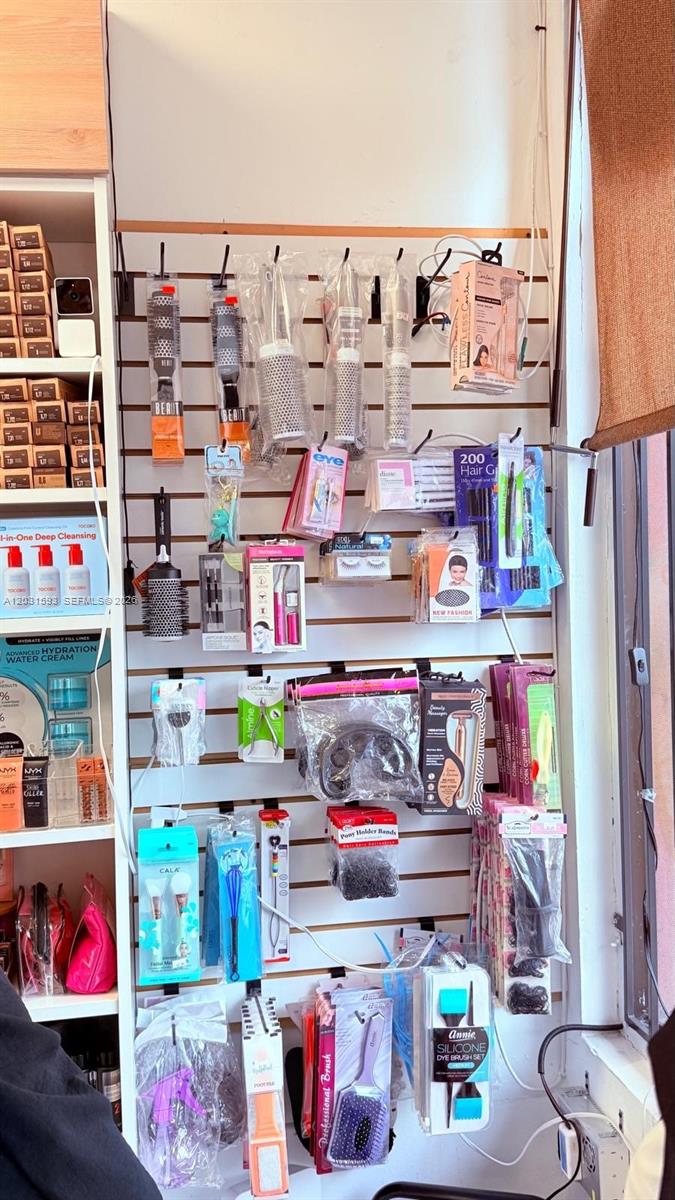 A retail display wall features various hair care tools, brushes, and beauty accessories on hooks — Beauty Supply Store, Miami FL 33125, MIAMI, FL