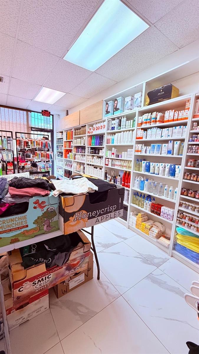 A retail store interior features shelves stocked with beauty products and boxes of apples — Beauty Supply Store, Miami FL 33125, MIAMI, FL