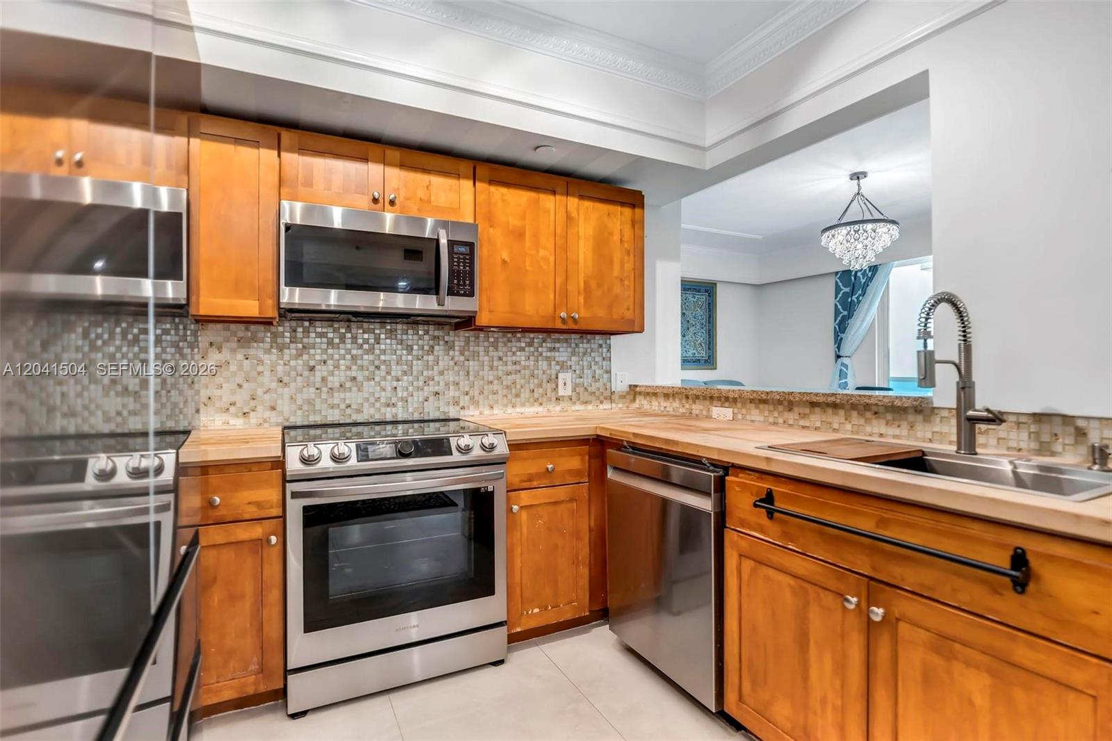 A kitchen features wooden cabinets, stainless steel appliances, a tiled backsplash, and butcher block countertops — 1723 SW 2nd Ave # 607, Miami FL 33129, MIAMI, FL