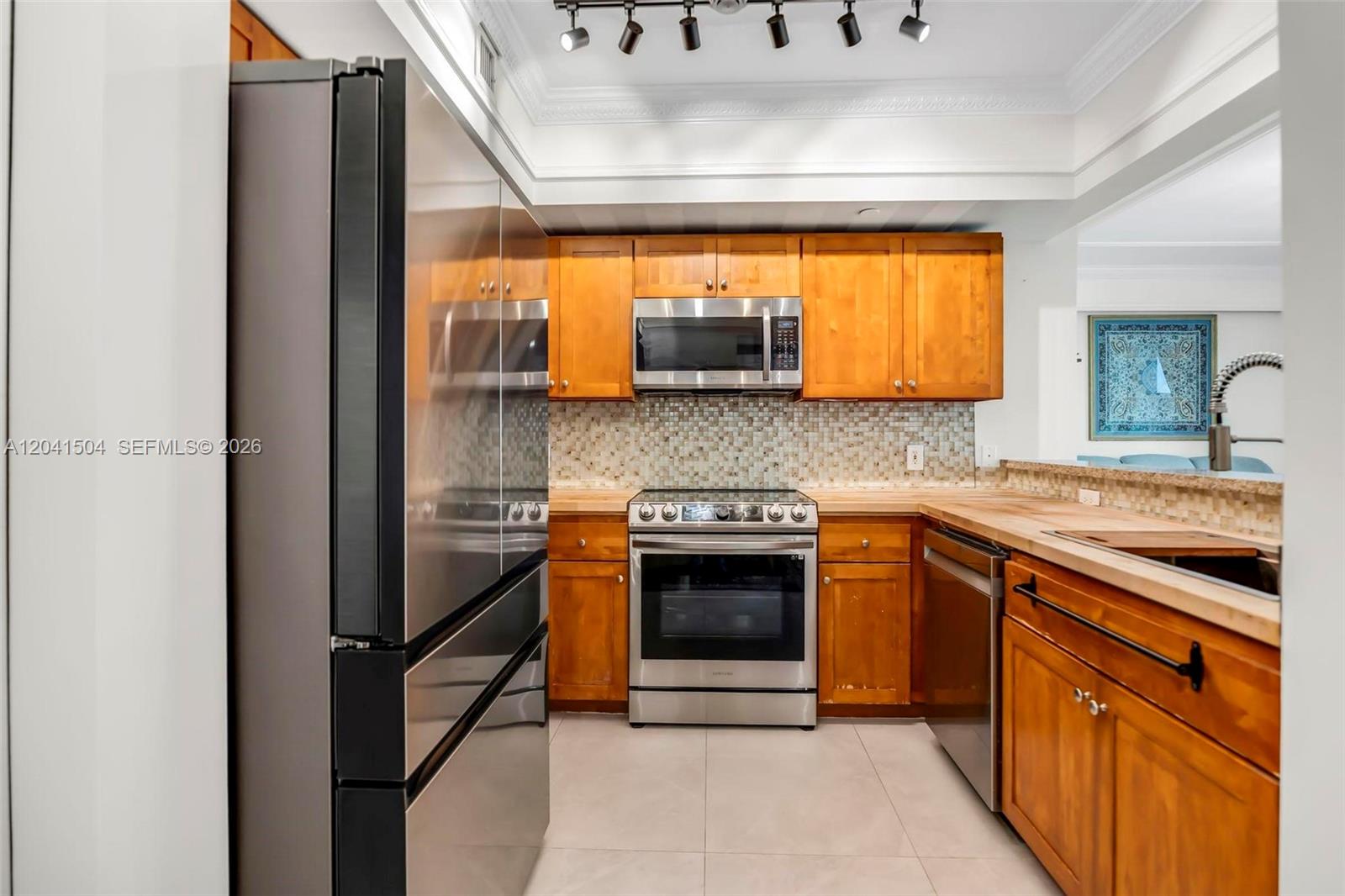 A kitchen features stainless steel appliances, wooden cabinets, and a tiled backsplash — 1723 SW 2nd Ave # 607, Miami FL 33129, MIAMI, FL
