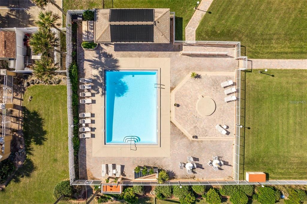 An aerial view shows a rectangular swimming pool surrounded by a paved patio and lounge chairs — 3600 S OCEAN SHORE BOULEVARD UNIT 423, FLAGLER BEACH, FL
