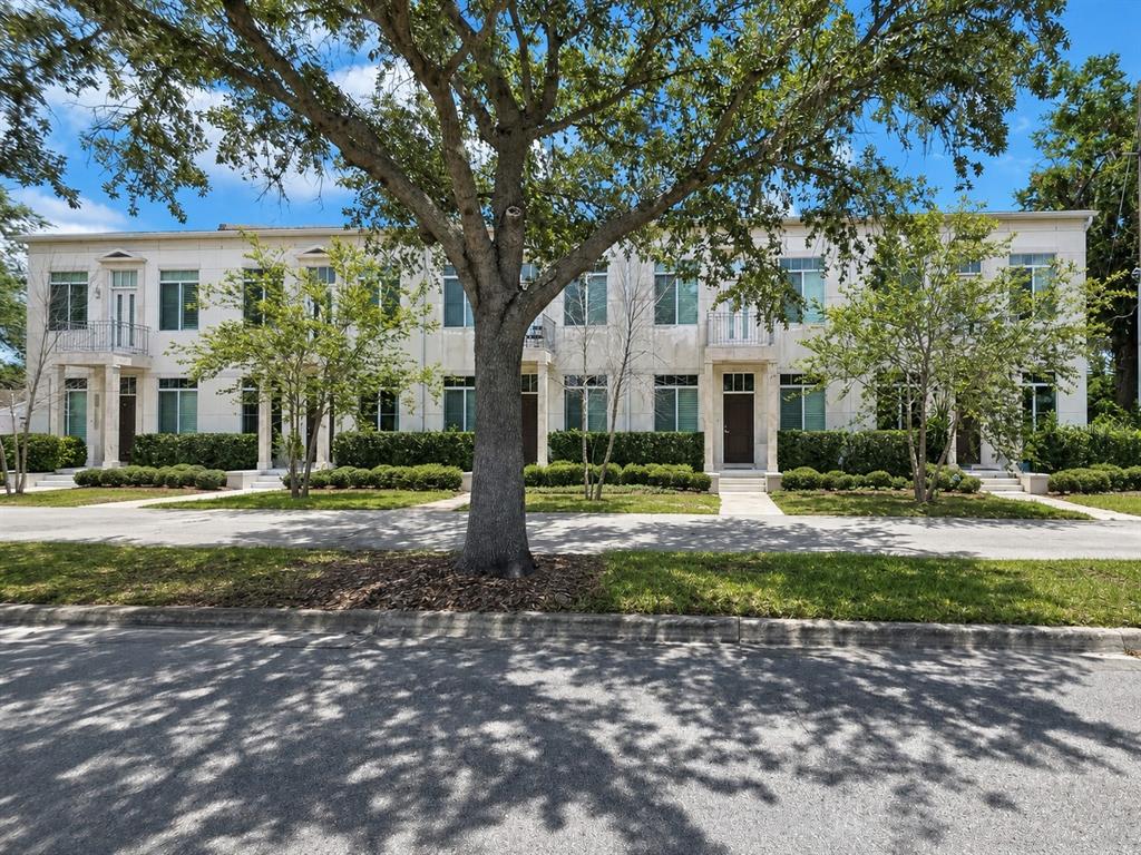 A two-story residential building with a light-colored facade, multiple entrances, and mature trees in front — 759 LAKE BALDWIN LANE, ORLANDO, FL