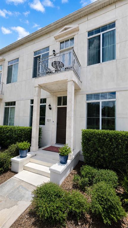 The exterior of a multi-story building features a balcony, a front door, and landscaping — 759 LAKE BALDWIN LANE, ORLANDO, FL