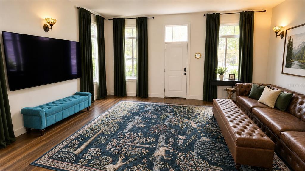 A living room features a large television, leather sofa, tufted bench, and patterned area rug — 759 LAKE BALDWIN LANE, ORLANDO, FL