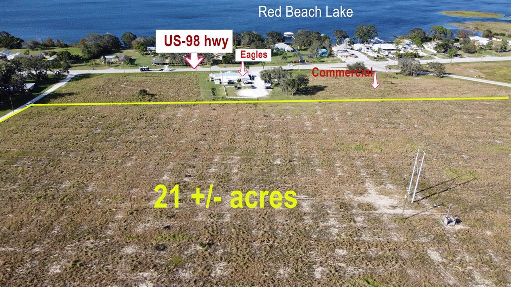 An aerial view shows a large, undeveloped plot of land near a lake and highway — 7655 CR 17 S, SEBRING, FL