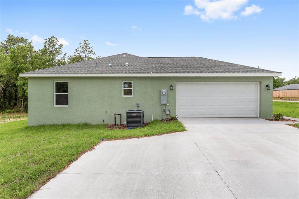 The exterior view shows a light green stucco house with a two-car garage and driveway — 3853 SW SOUNDVIEW DRIVE, DUNNELLON, FL