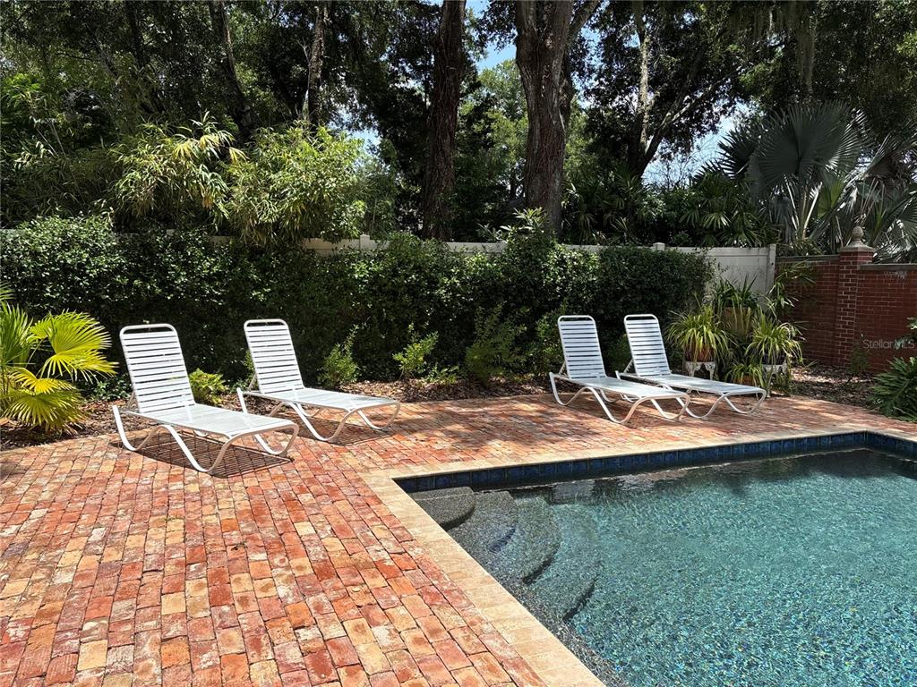 A white picket fence encloses the front yard of a single-story house with a red door — 1046 N MCDONALD STREET, MOUNT DORA, FL