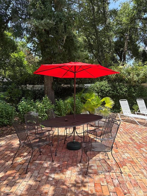 A single-story house with gray siding, a metal roof, and a brick walkway in front — 1046 N MCDONALD STREET, MOUNT DORA, FL