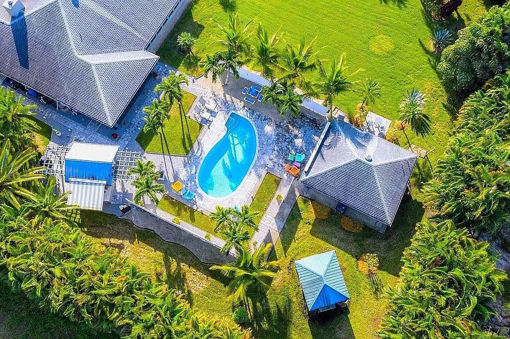 An aerial view of a house with a swimming pool, patio, and surrounding tropical landscaping — 16826 126th Terrace N, Jupiter FL 33478, JUPITER, FL