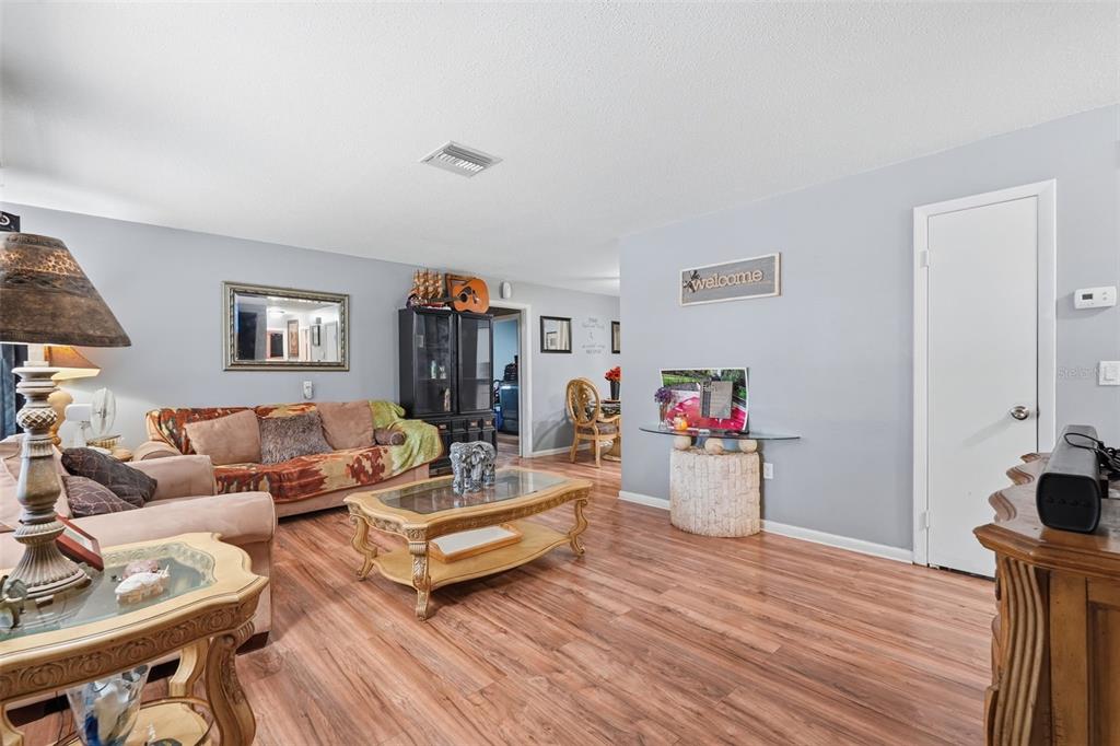 A living room features wood-look flooring, a beige sofa, a coffee table, and gray walls — 8509 W KIPLING LANE, HOMOSASSA, FL