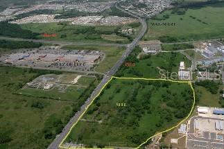 An aerial view shows a vacant, undeveloped plot of land outlined in yellow near a highway — 66 ROAD 66 & ROAD 3, CANOVANAS, PR