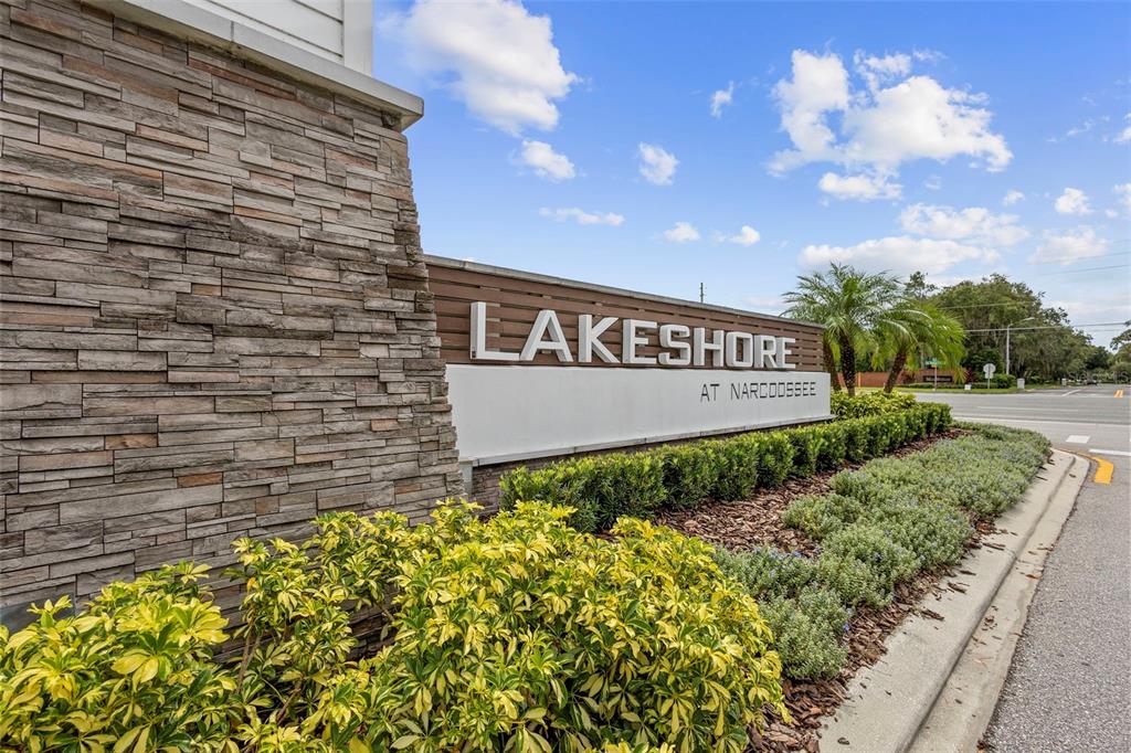 A stone-faced monument sign displays the name Lakeshore at Narcoossee near a road — 5030 CASPIAN STREET, ST CLOUD, FL
