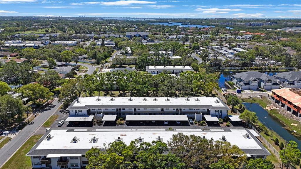 An aerial view shows two long apartment buildings with white roofs and attached parking carports — 7700 92ND STREET UNIT 207, SEMINOLE, FL
