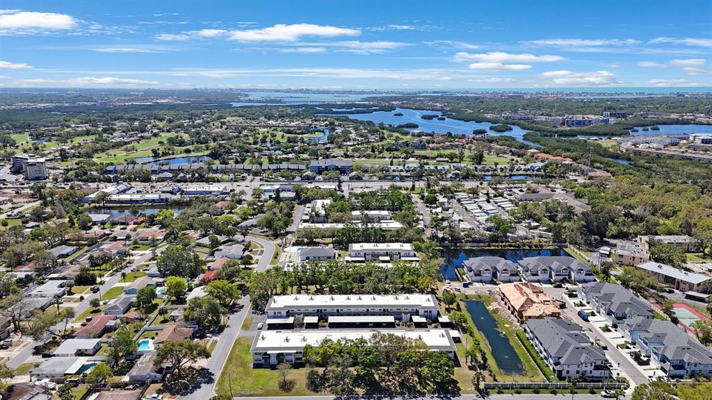 An aerial view shows a residential complex with multi-story buildings, parking lots, and a pond — 7700 92ND STREET UNIT 207, SEMINOLE, FL