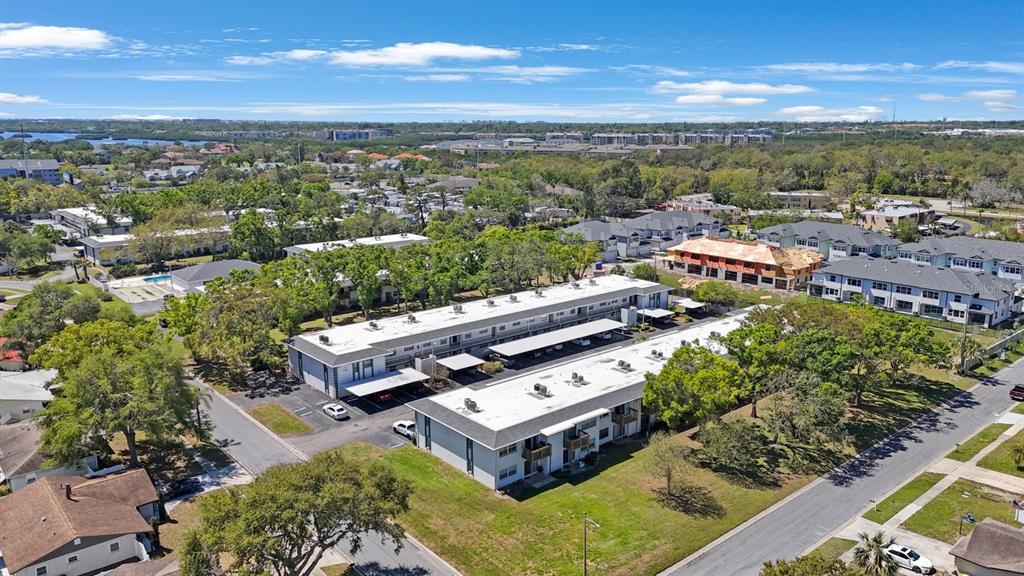 An aerial view shows two long, multi-story apartment buildings with flat roofs and parking carports — 7700 92ND STREET UNIT 207, SEMINOLE, FL