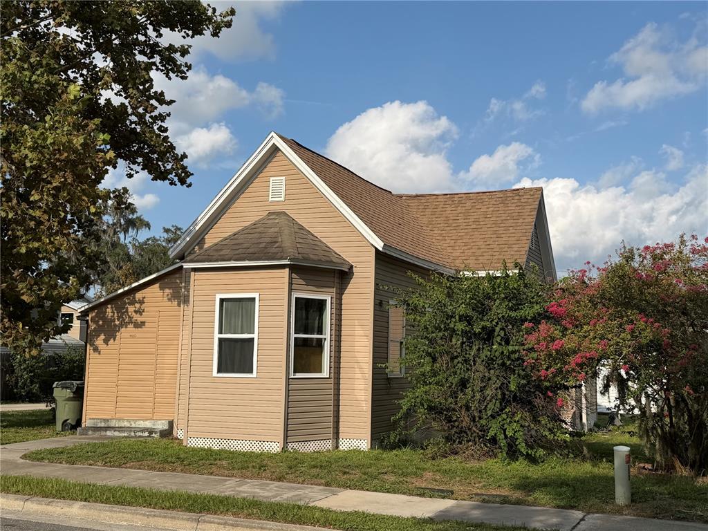 A tan, single-story house with a bay window and brown shingled roof — 400 S 6TH STREET, LEESBURG, FL