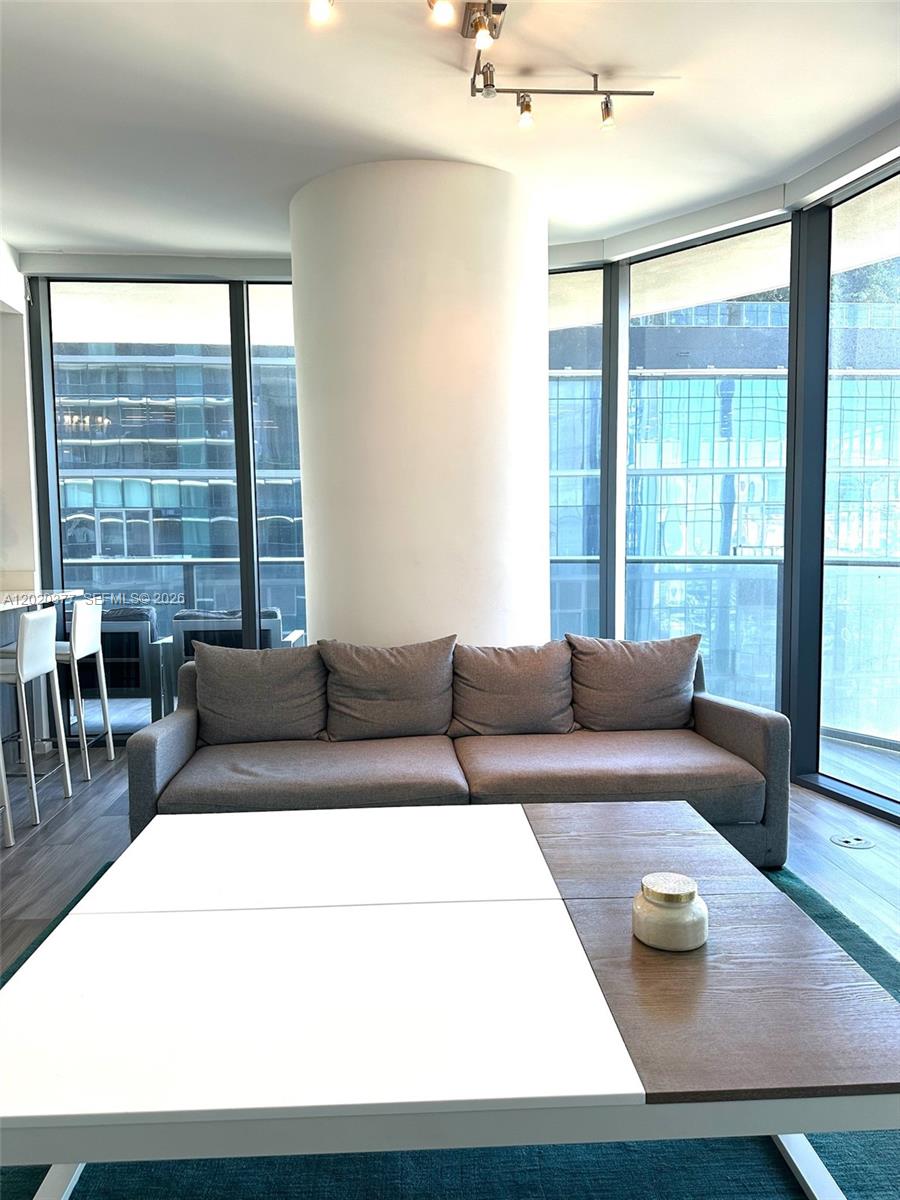 A living room features a gray sofa, a two-toned coffee table, and floor-to-ceiling windows — 801 S Miami Ave # 4305, Miami FL 33130, MIAMI, FL
