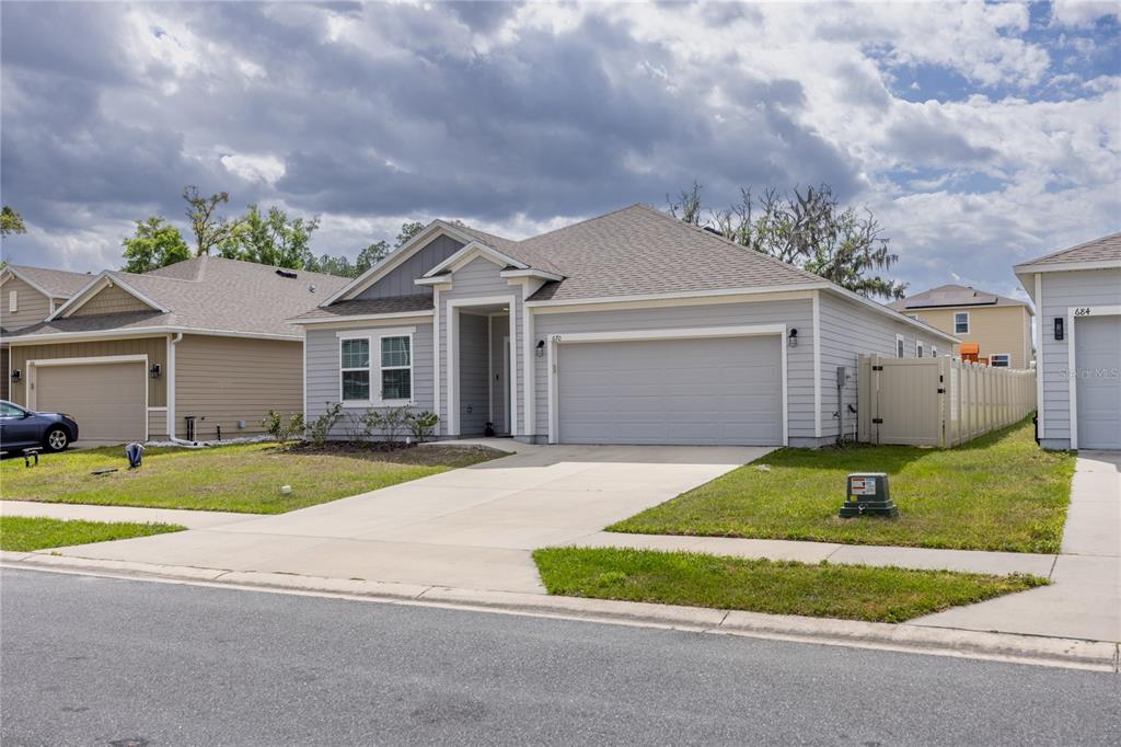 A gray single-story house with a two-car garage and a concrete driveway — 670 NW 243RD TERRACE, NEWBERRY, FL