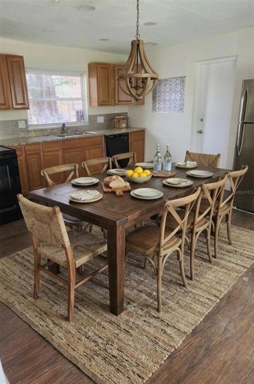 A dining area features a wooden table with eight chairs on a large jute rug — 2421 ARCHER BOULEVARD, ORLANDO, FL