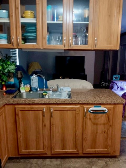 A kitchen features light wood cabinets, a granite countertop, and a stainless steel sink — 17749 SE 156TH PLACE ROAD, WEIRSDALE, FL