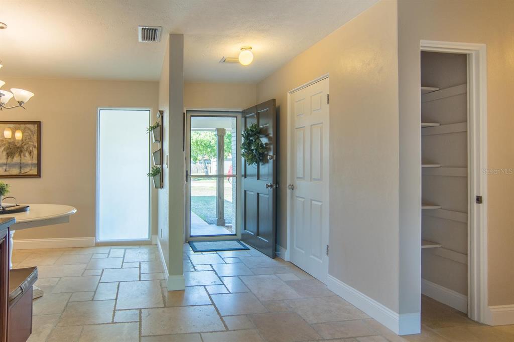 An entryway features tile flooring, a front door with a screen, and an open pantry — 542 59TH WAY S, ST PETERSBURG, FL