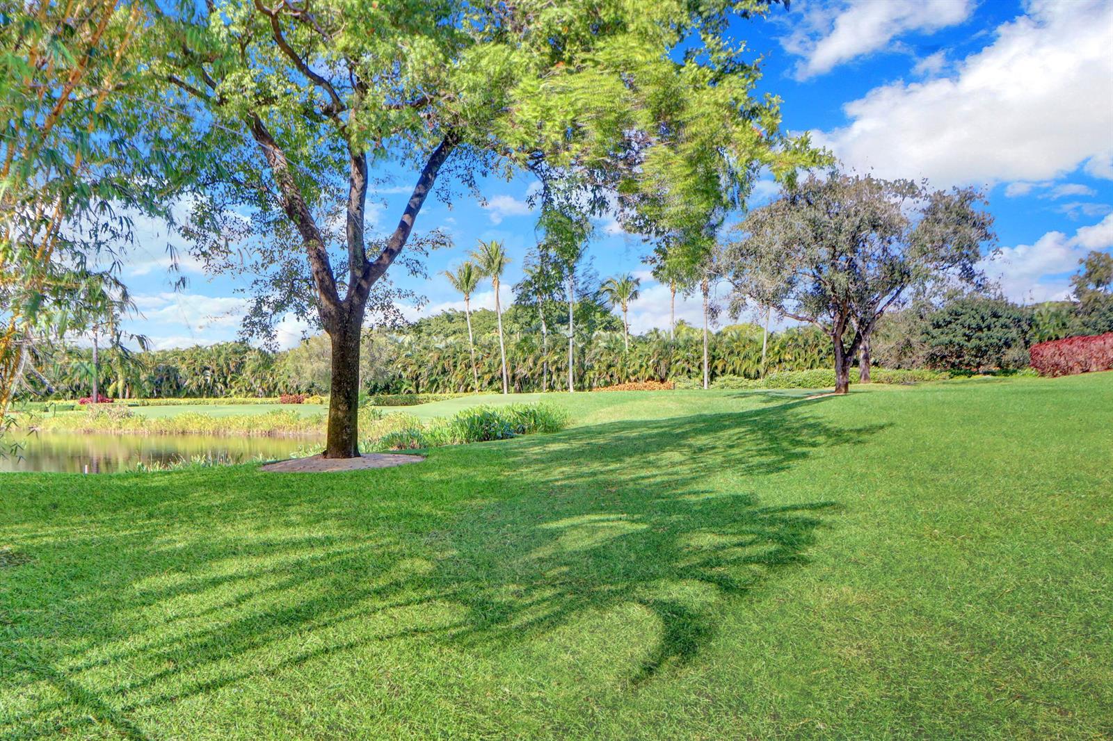 A large tree stands on a grassy lawn beside a pond on a golf course — 3799 Coventry Lane, Boca Raton FL 33496, BOCA RATON, FL