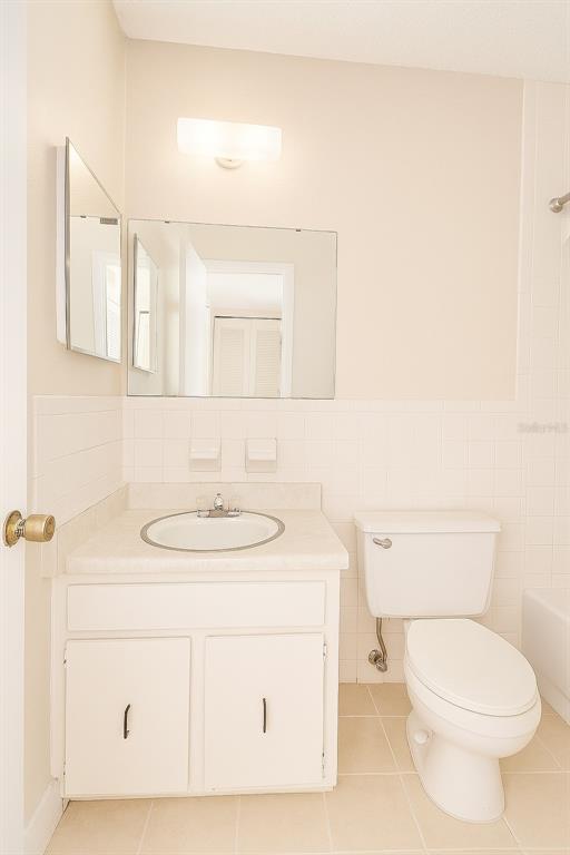 A bathroom features a white vanity with a sink, a mirror, and a toilet — 2417 NE 6TH STREET UNIT 8, OCALA, FL