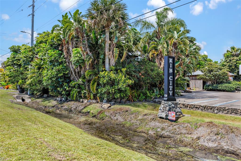 A Rib City sign stands near a drainage ditch in front of lush tropical landscaping — 5390 US HIGHWAY 1, GRANT VALKARIA, FL