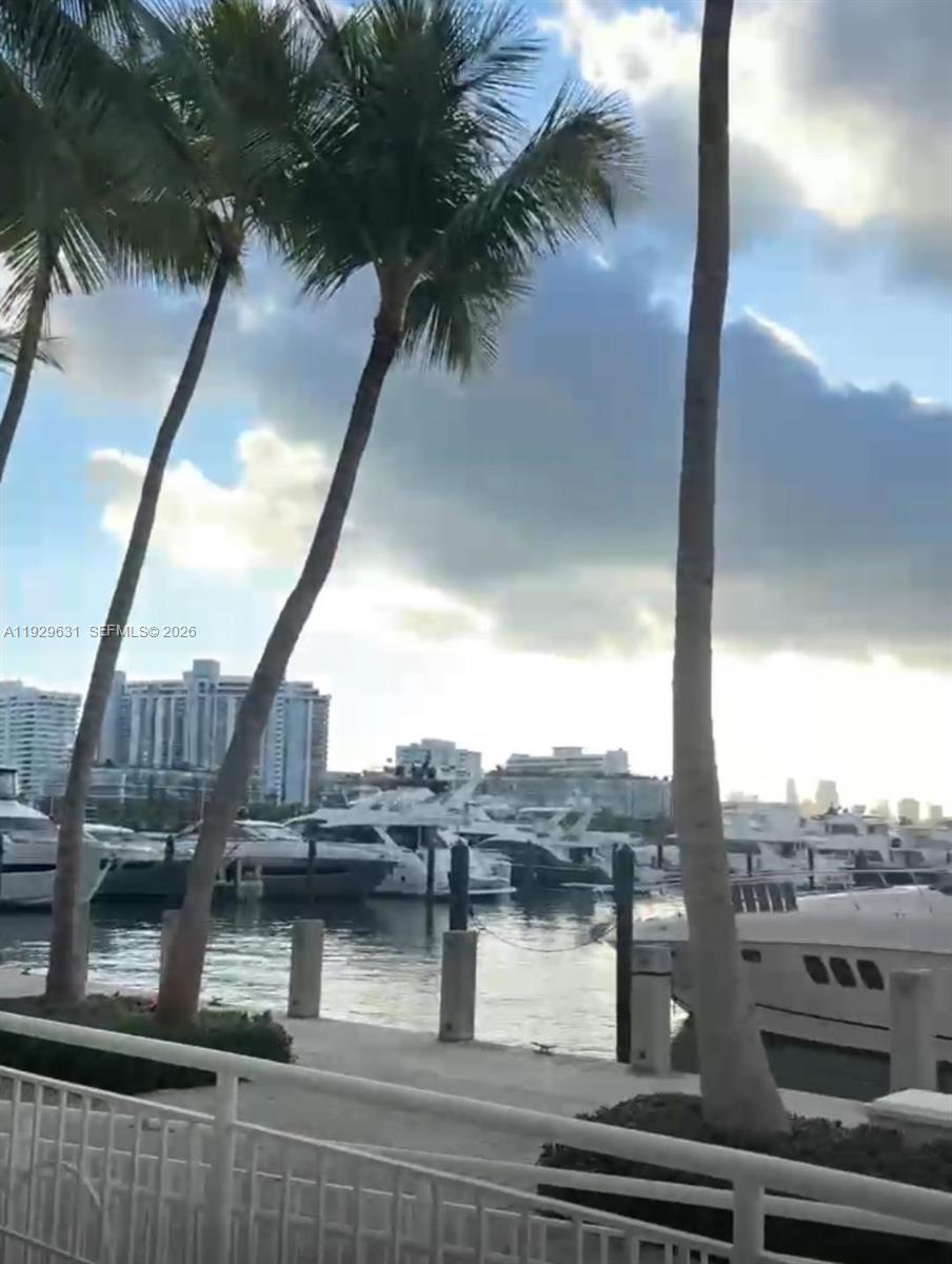 A view of a marina with docked yachts and palm trees under a cloudy sky — 1800 Sunset Harbour Dr, Miami Beach FL 33139, MIAMI BEACH, FL