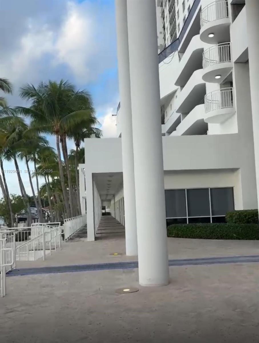 A paved walkway runs alongside a white building with large columns and palm trees — 1800 Sunset Harbour Dr, Miami Beach FL 33139, MIAMI BEACH, FL